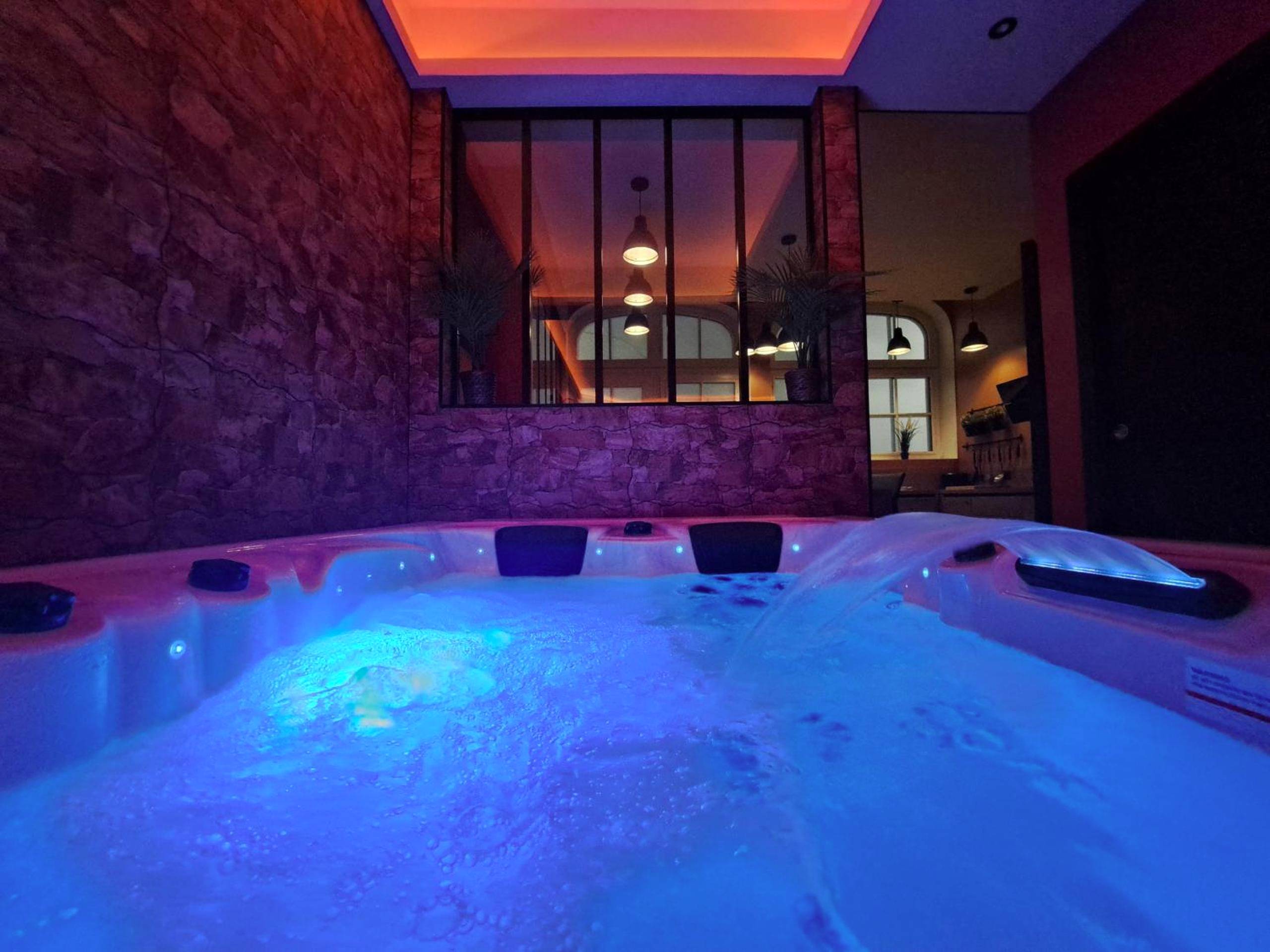 Jacuzzi bouillonnant avec cascade lumineuse - Ospaloft, meublé haut de gamme avec spa privatif