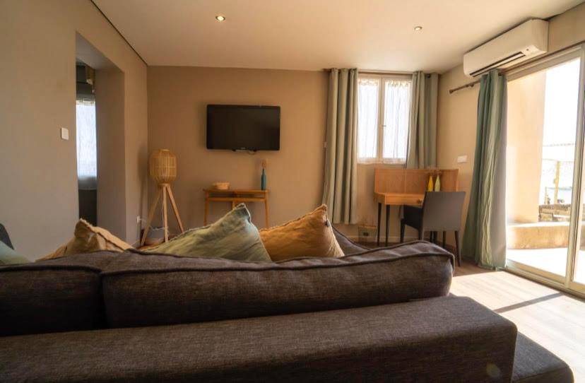 Salon avec canapé d'angle et télévision murale - Palm Beach