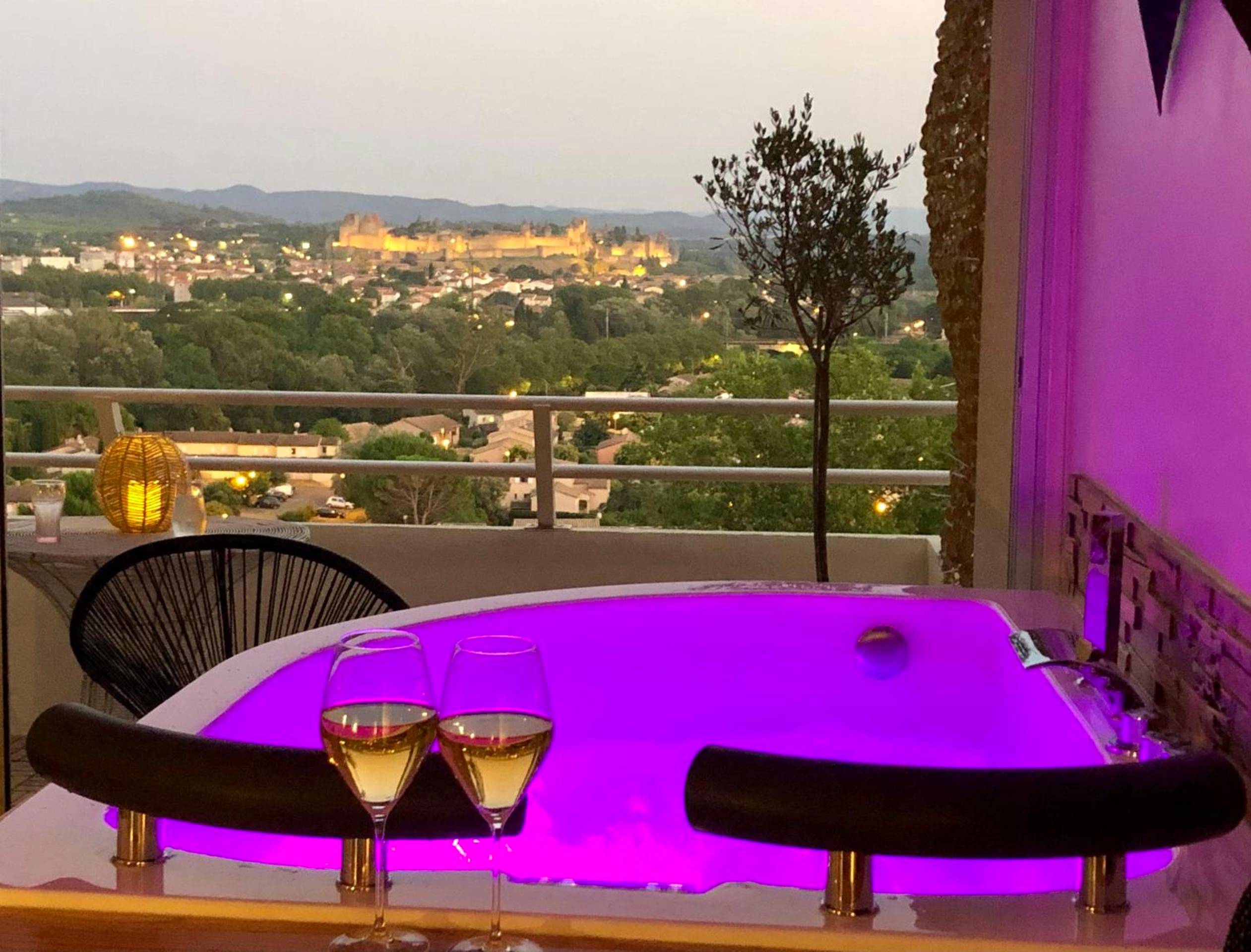 Jacuzzi avec vue sur la cité médiévale de nuit - Love Room Carcassonne - Panorama Suite & Spa