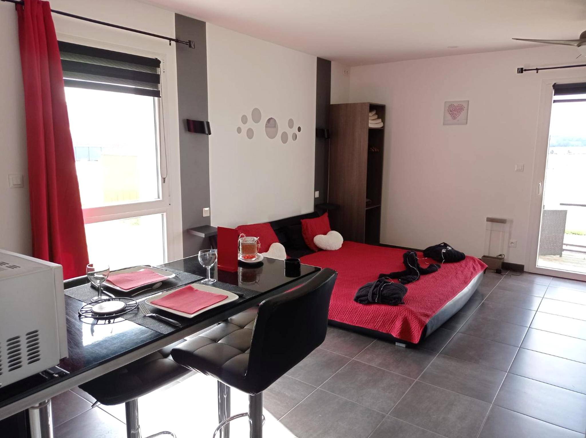 Lit double rouge et coin repas moderne - Paradis Secret Spa
