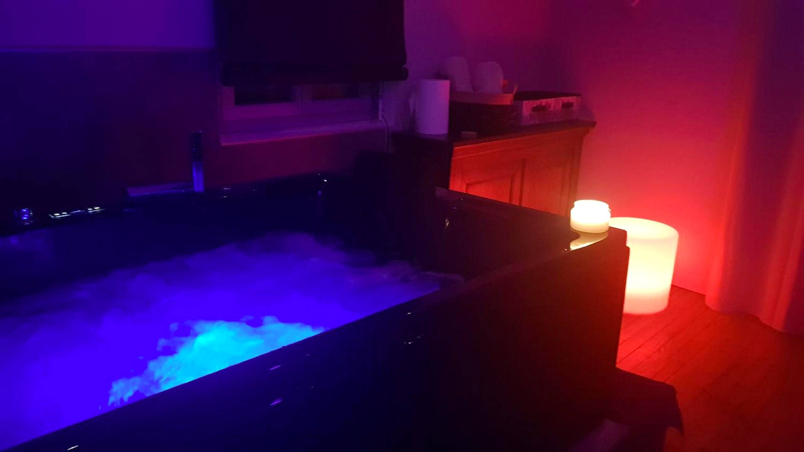 Jacuzzi privatif avec éclairage bleu et bougies - Love Room Floirac - Une Parenthese