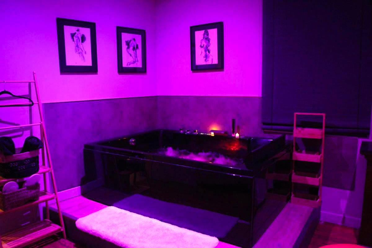 Baignoire balnéo noire sous lumière violette - Une Parenthese