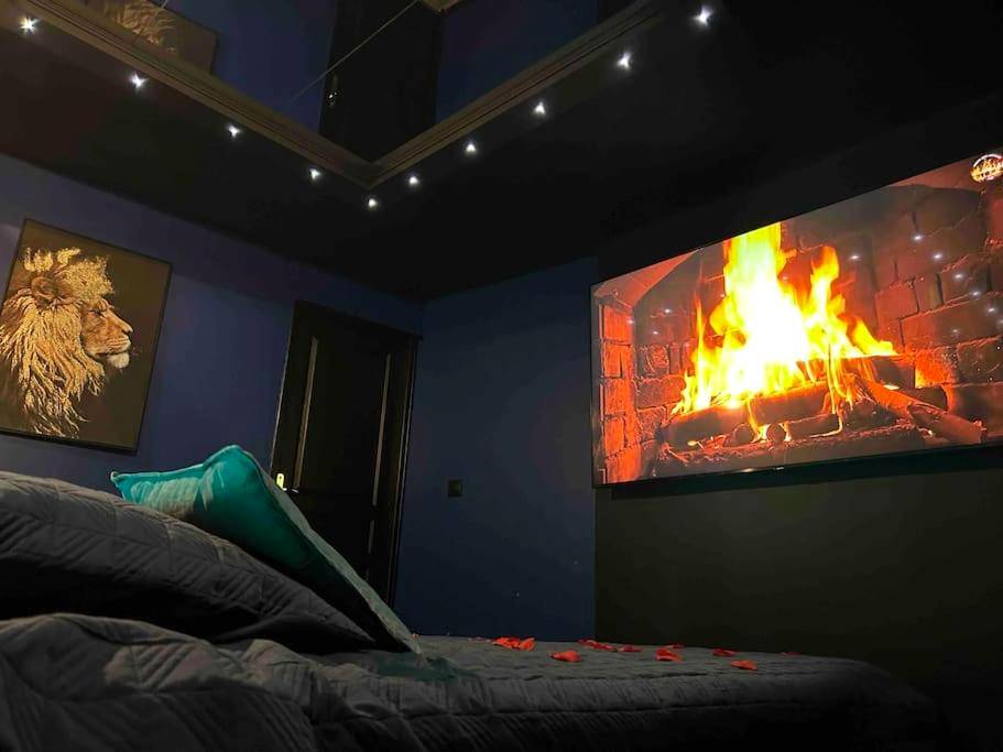 Écran géant face au lit avec feu de cheminée - Love room La Parenthèse Carnoules