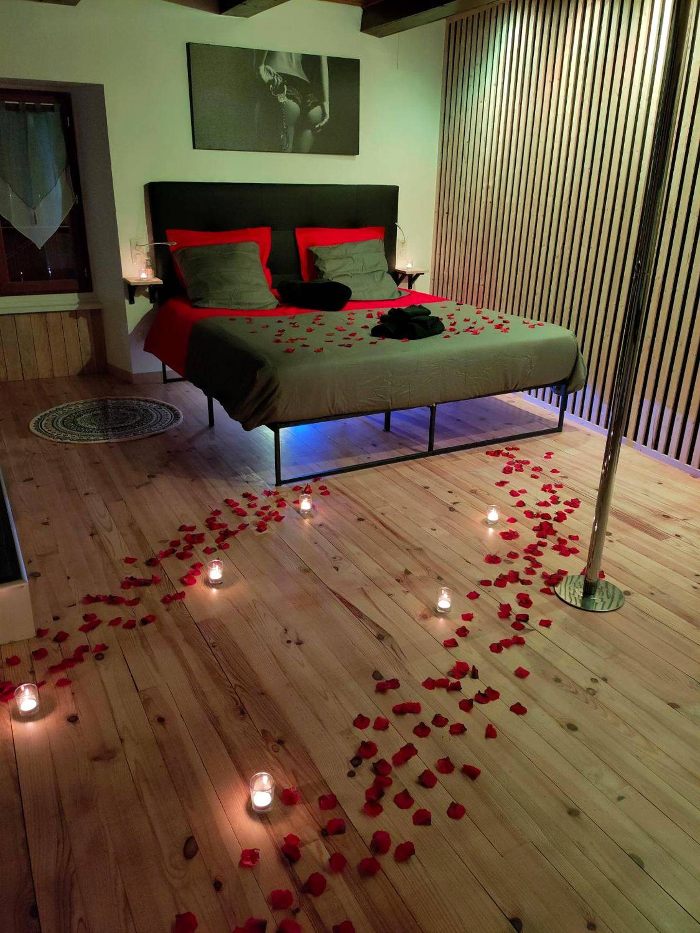 Lit double avec pétales de rose et bougies - Love Room Saurier - La parenthèse coquine