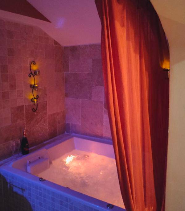 Jacuzzi privatif illuminé et bouteille de vin - Une Parenthese pour Deux