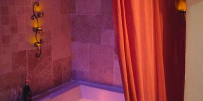 Jacuzzi privatif illuminé et bouteille de vin - Une Parenthese pour Deux