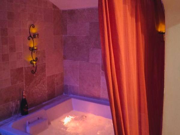 Jacuzzi privatif illuminé et bouteille de vin - Une Parenthese pour Deux