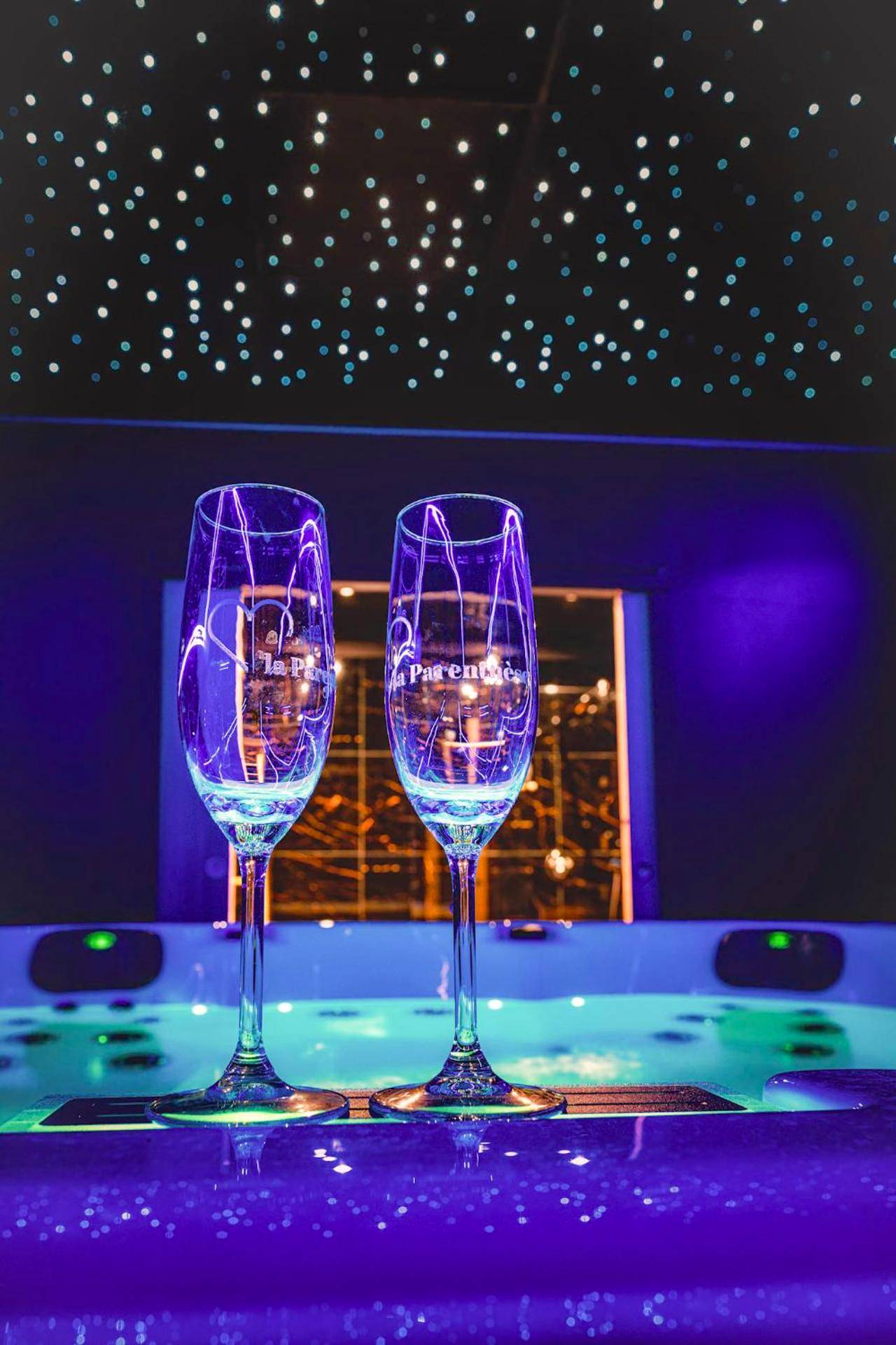 Coupes de champagne au bord du jacuzzi - La Parenthèse Jacuzzi sauna privatif Cognac