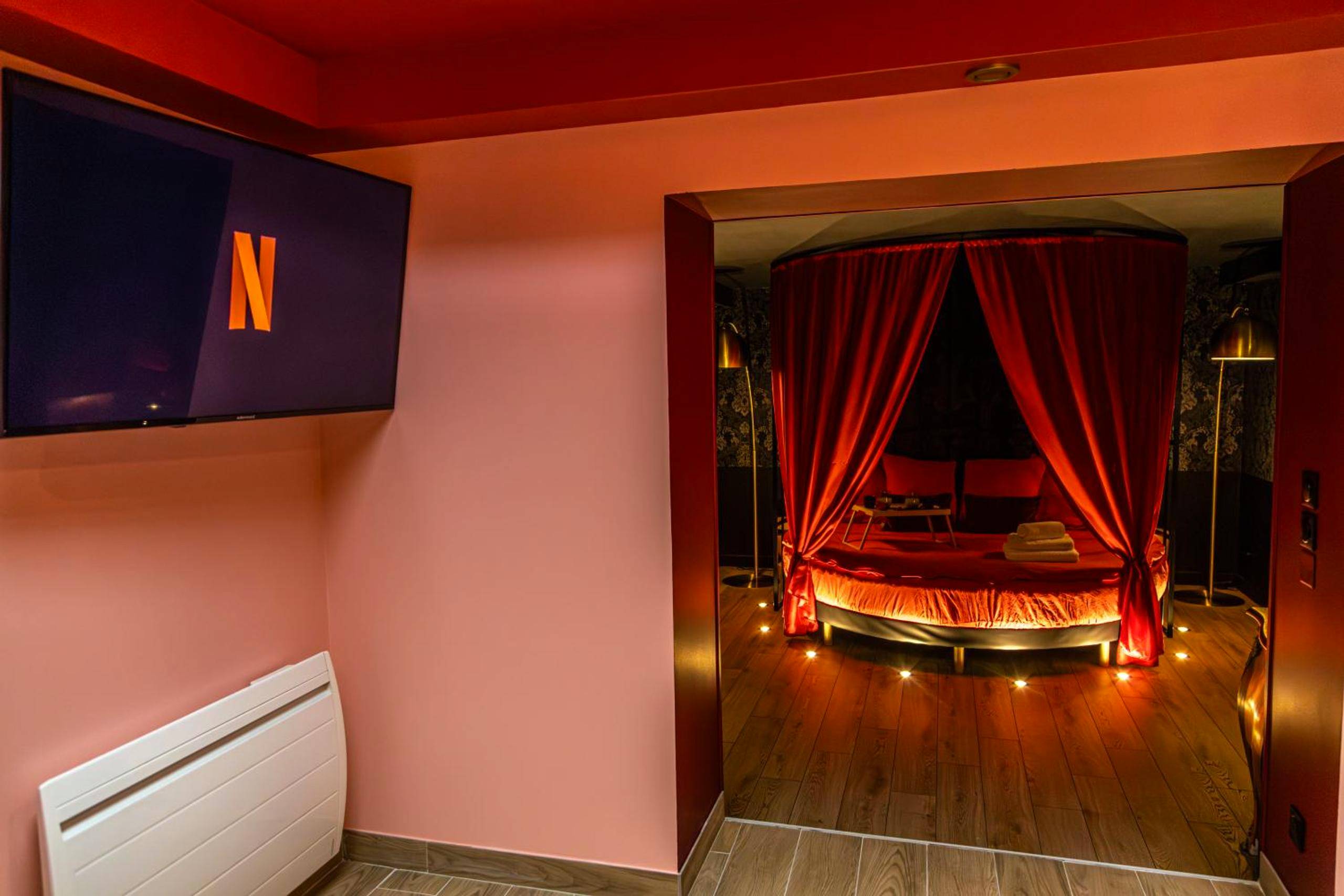 Espace salon avec TV et vue sur lit rond - La Parenthèse Numéro 6 - Jacuzzi Reims