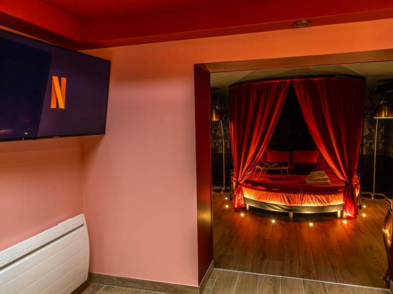 Espace salon avec TV et vue sur lit rond - La Parenthèse Numéro 6 - Jacuzzi Reims