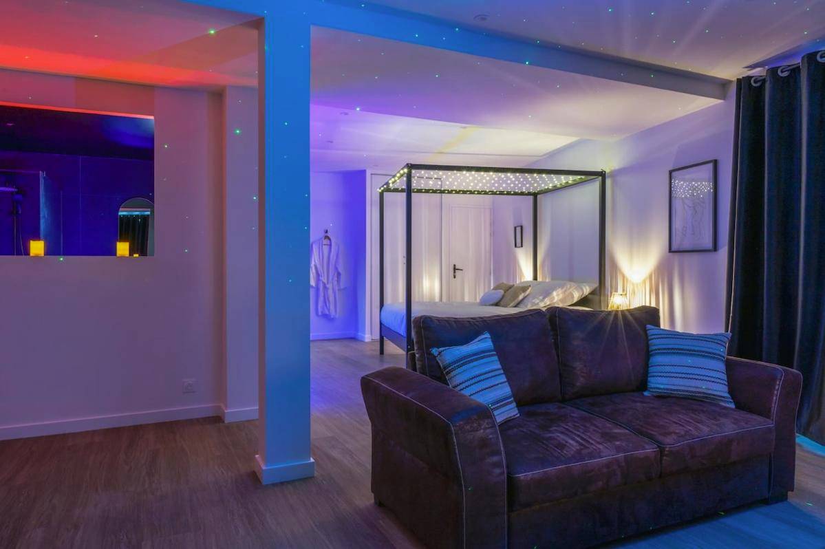 Salon et chambre avec jeux de lumières colorées - La Parenthèse Sensuelle - love room