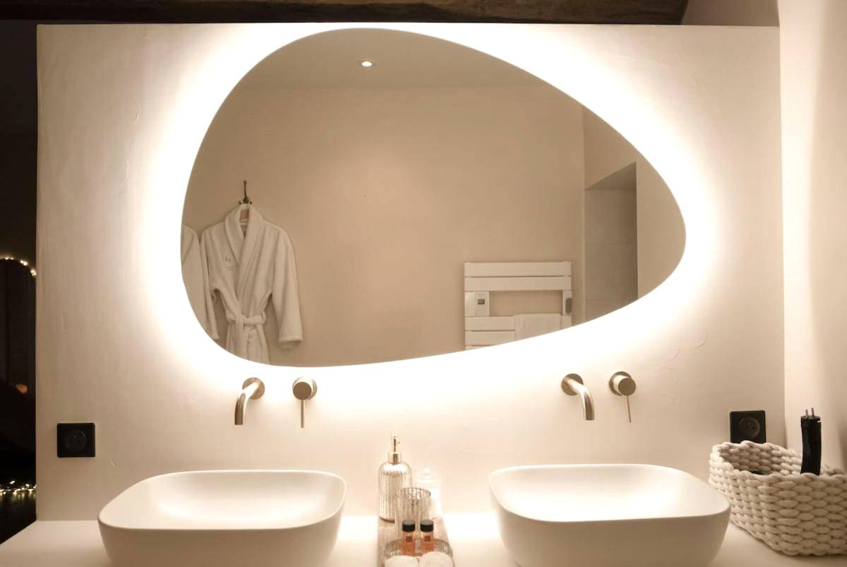 Double vasque avec miroir organique lumineux - La Parenthèse Suites - appartement luxueux avec sauna et baignoire balnéo