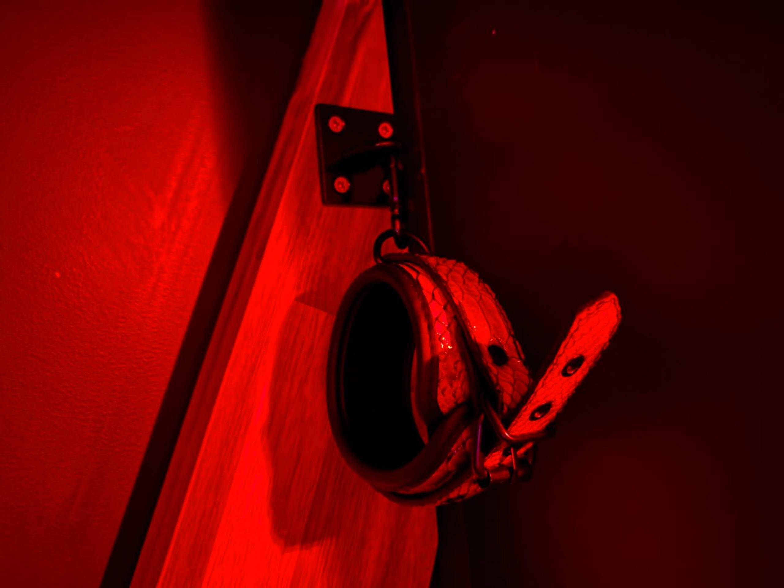 Détail d'une menotte en cuir fixée au mur - Love room in Paris