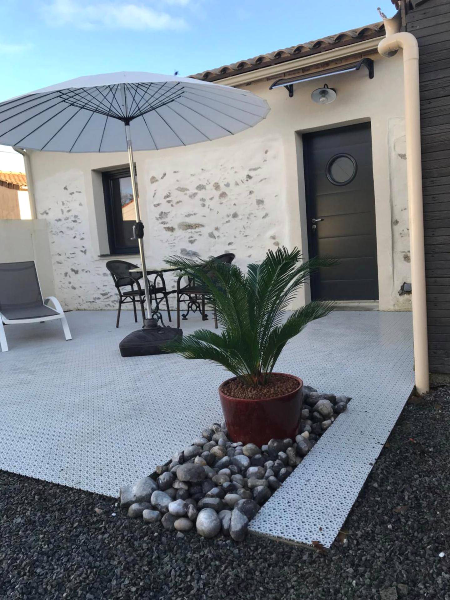 Terrasse aménagée avec parasol et salon de jardin - La Passionnante Gîte avec Spa privatif