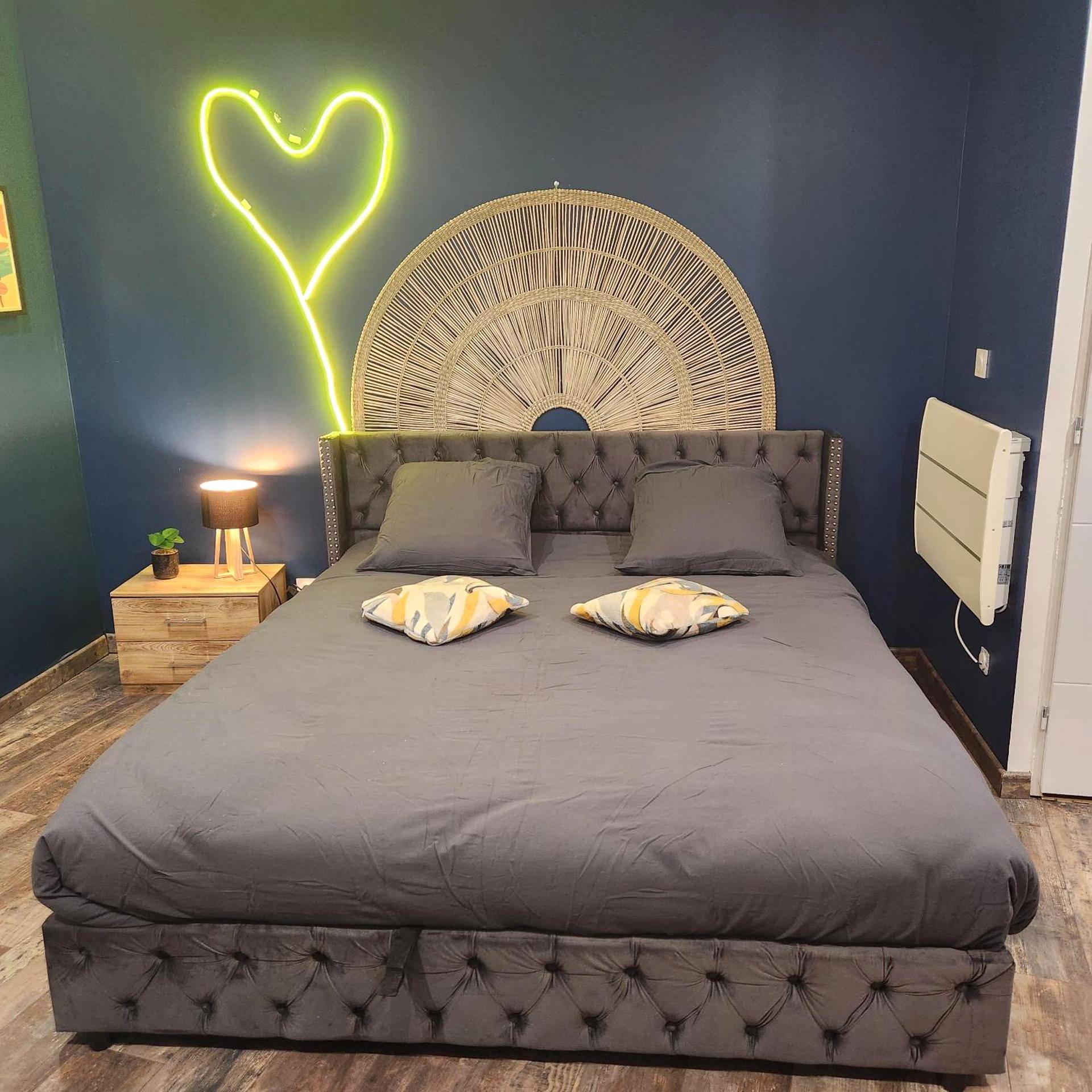 Lit double avec néon cœur et tête de lit rotin - Loveroom Pau
