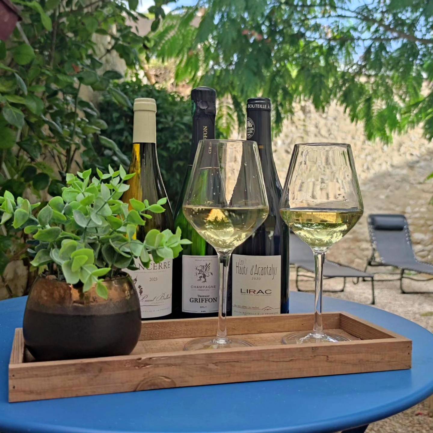 Bouteilles de vin et verres sur table extérieure - Love Room Une Pause à Deux - Jacuzzi - Chambre Secrète