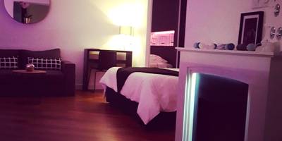 Salon avec cheminée décorative et lit en fond - La Pause Romantique