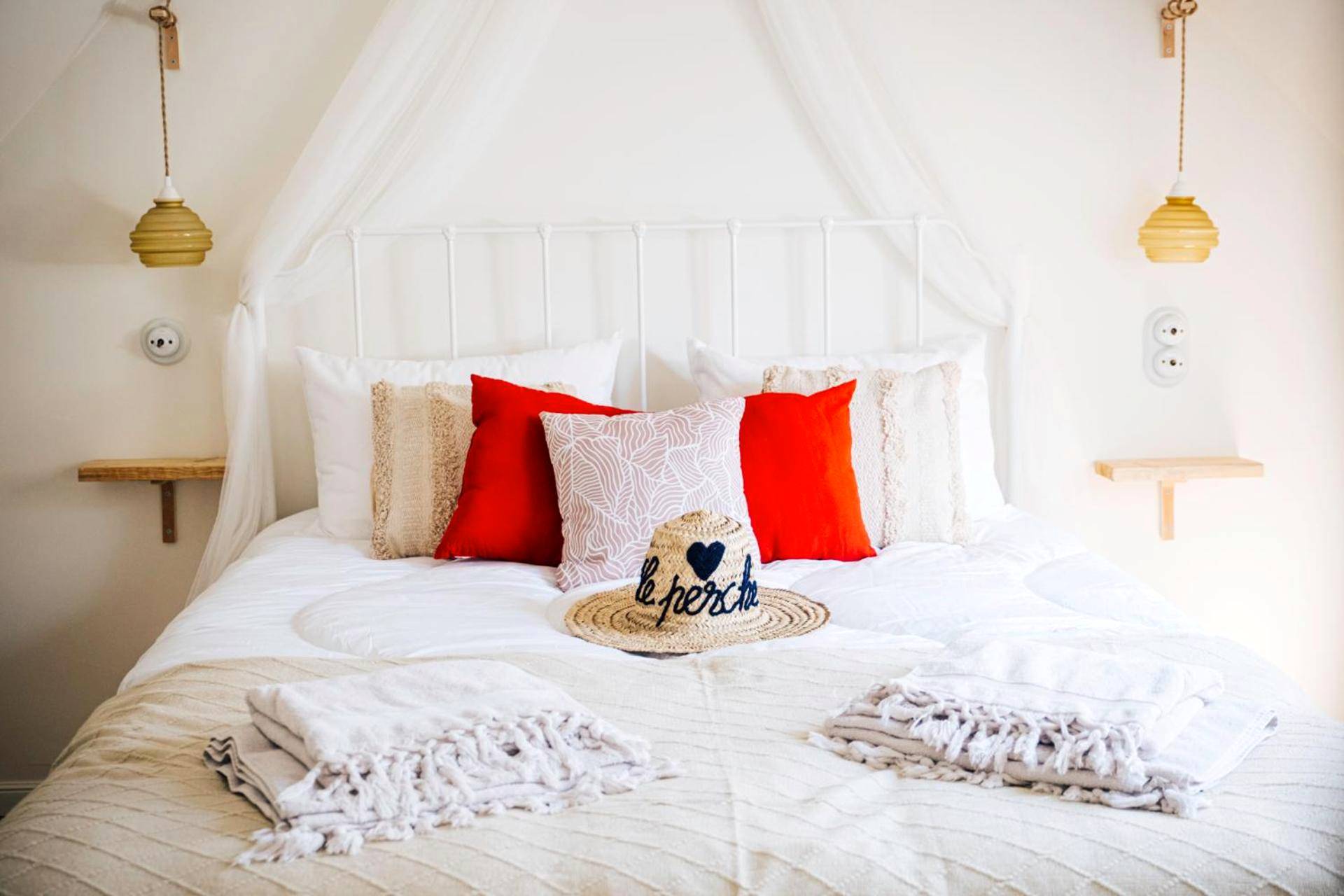 Lit double avec coussins rouges et chapeau - Love Room Moulins - la - Marche - Loveroom Du Perche : maison avec balnéo
