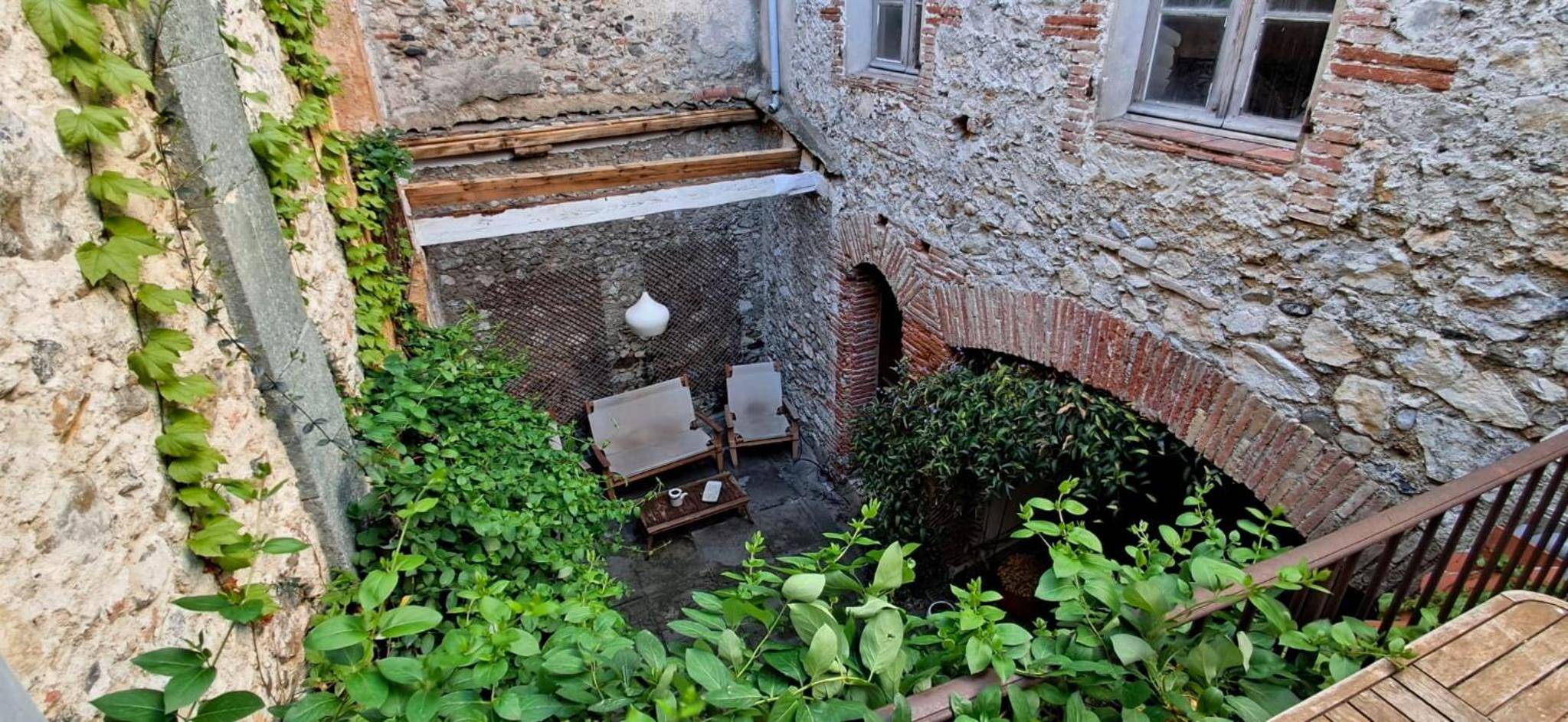 Patio intérieur avec murs en pierre et verdure - Love room Perpignan - 35mn de Perpignan