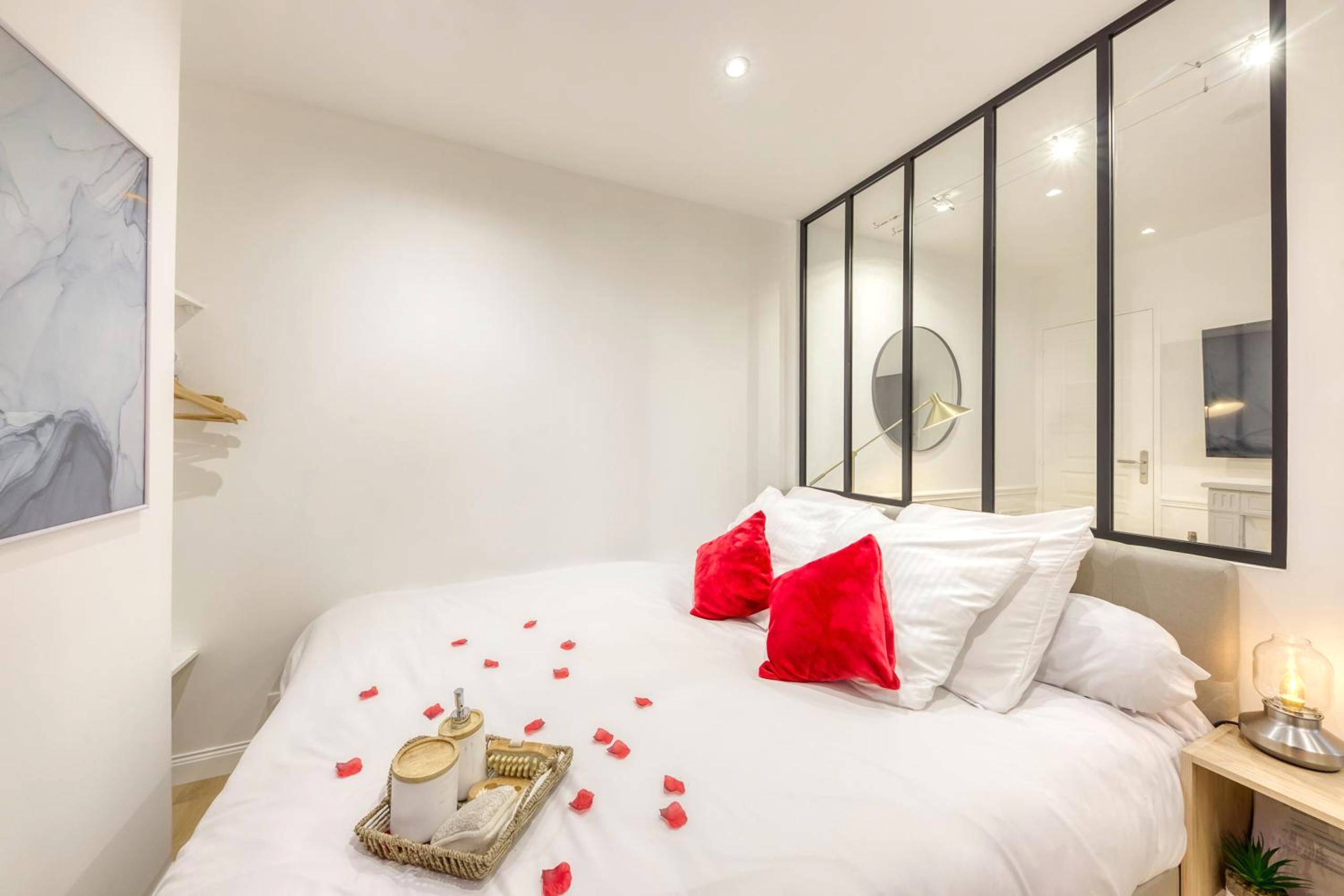Lit double avec pétales de rose et verrière - Le Petit Paris - Cocon & Spa & Sauna