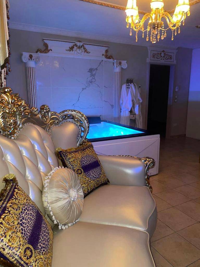 Canapé baroque et jacuzzi avec éclairage bleu - Love Room Vernon - Le Petit Versailles