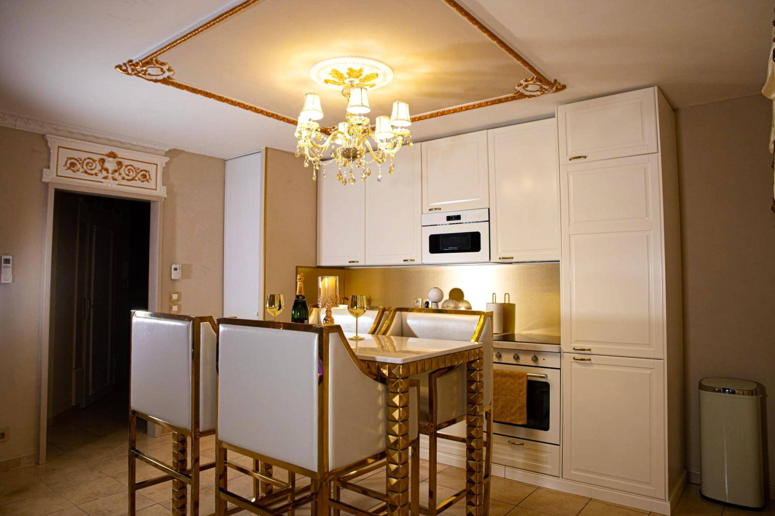 Cuisine équipée blanche et table haute dorée - Le Petit Versailles