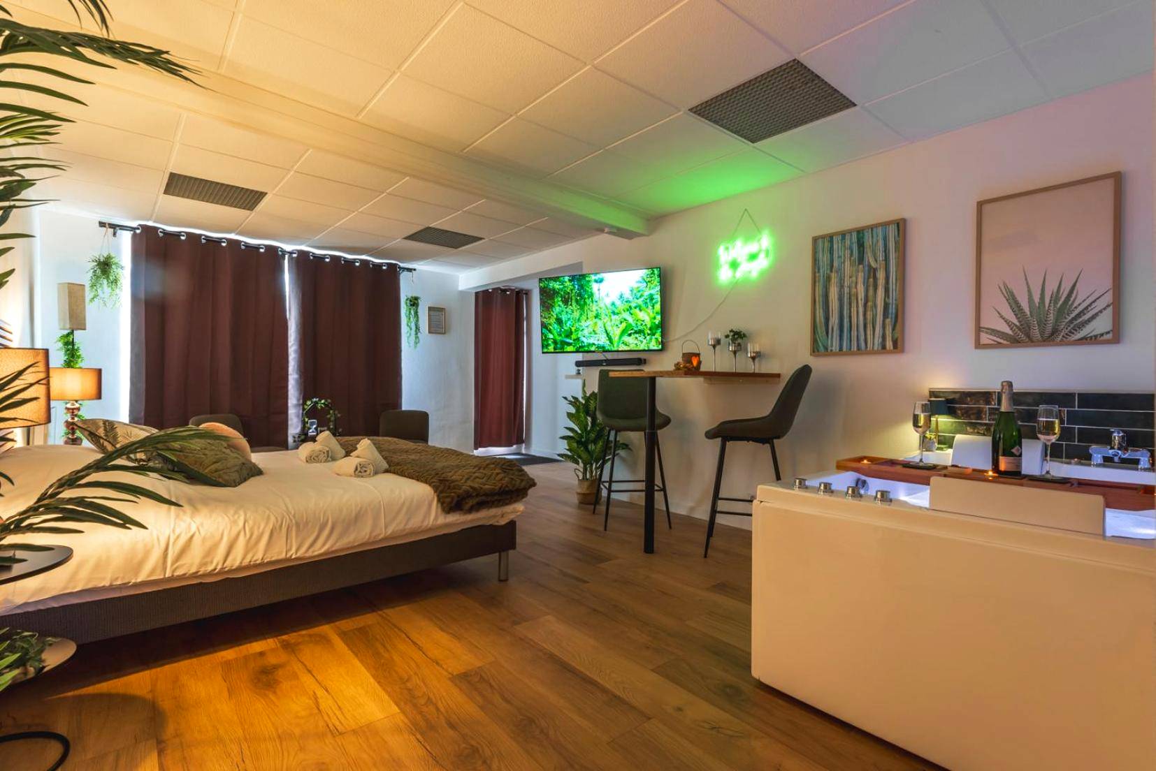 Vue d'ensemble avec lit, TV et jacuzzi - La Petite Jungle Romantique - Balnéo et Détente