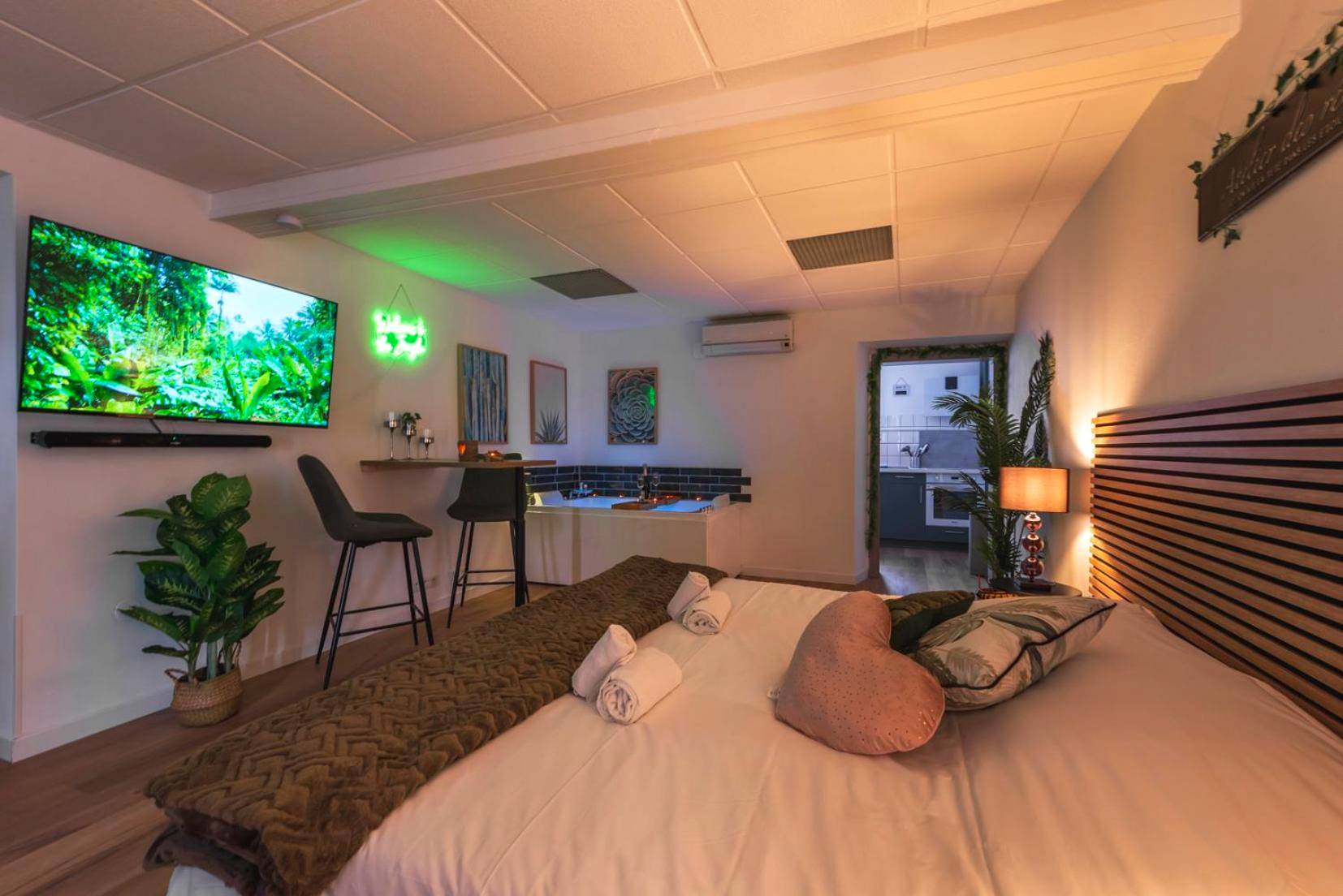Lit double avec coussin cœur et écran géant - La Petite Jungle Romantique - Balnéo et Détente