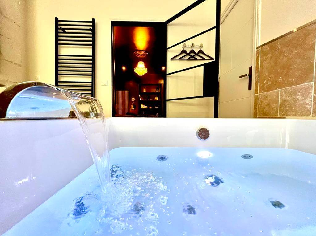 Jacuzzi privatif éclairé face à la chambre - Love Room Secrète Les Petits Plaisirs