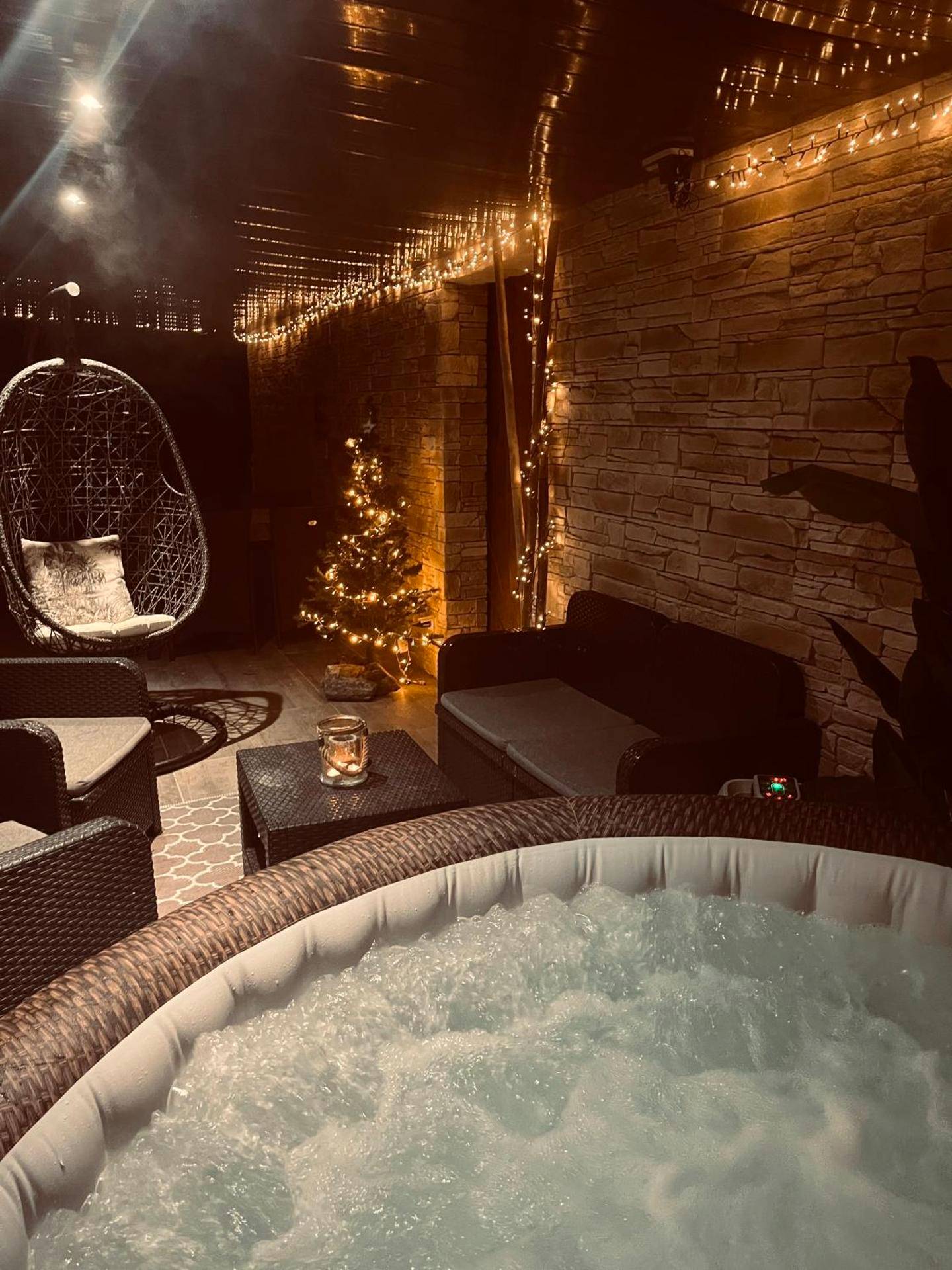Espace détente nocturne avec jacuzzi et guirlandes - Logement cosy avec piscine et jacuzzi privatifs