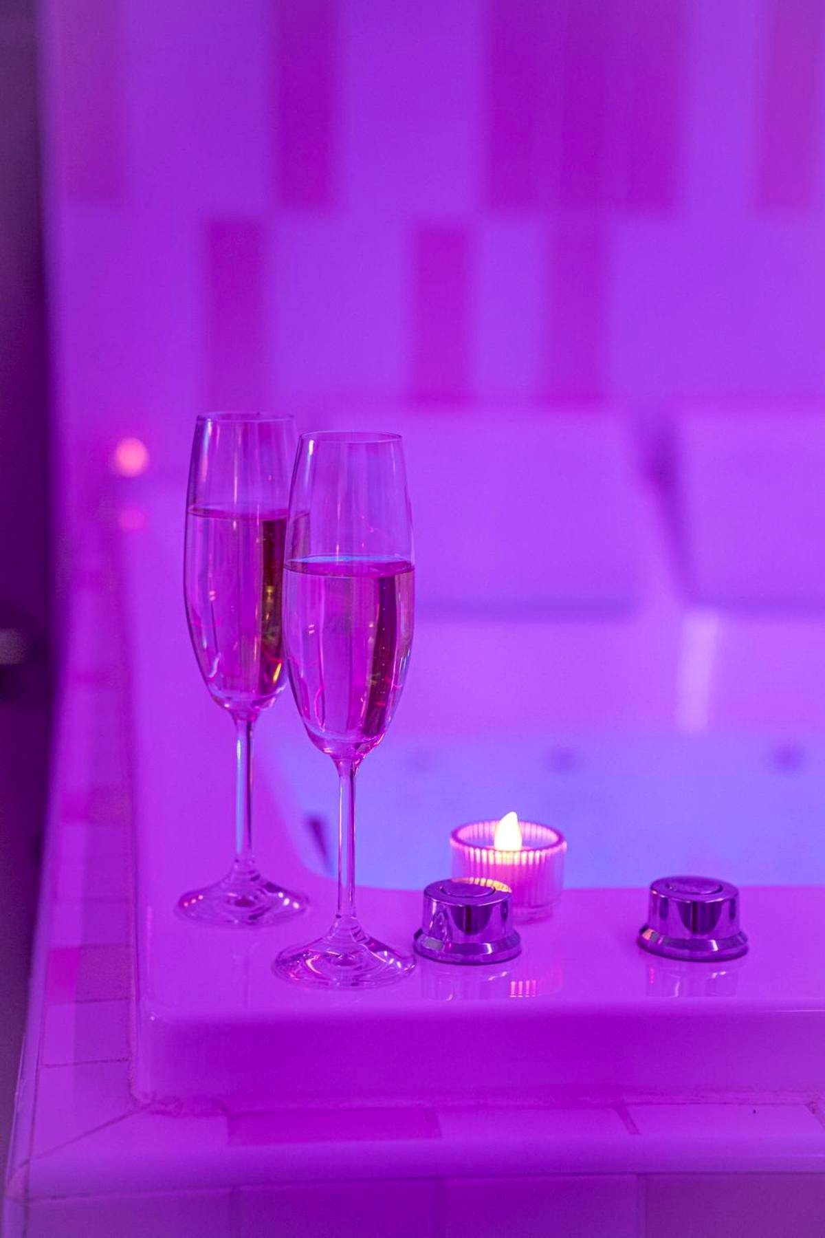 Flûtes de champagne au bord d'un jacuzzi rose - Love Room Questembert - Love room à 30 mn des plages et de Vannes