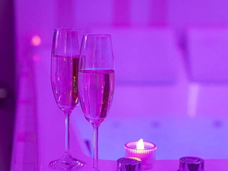 Flûtes de champagne au bord d'un jacuzzi rose - Love Room Questembert - Love room à 30 mn des plages et de Vannes