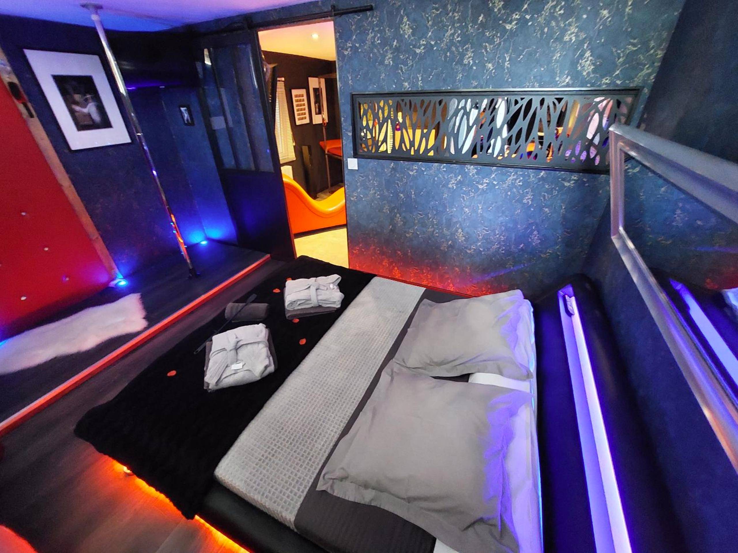 Lit double avec peignoirs et barre de pole dance - PLAISIR EXTREME