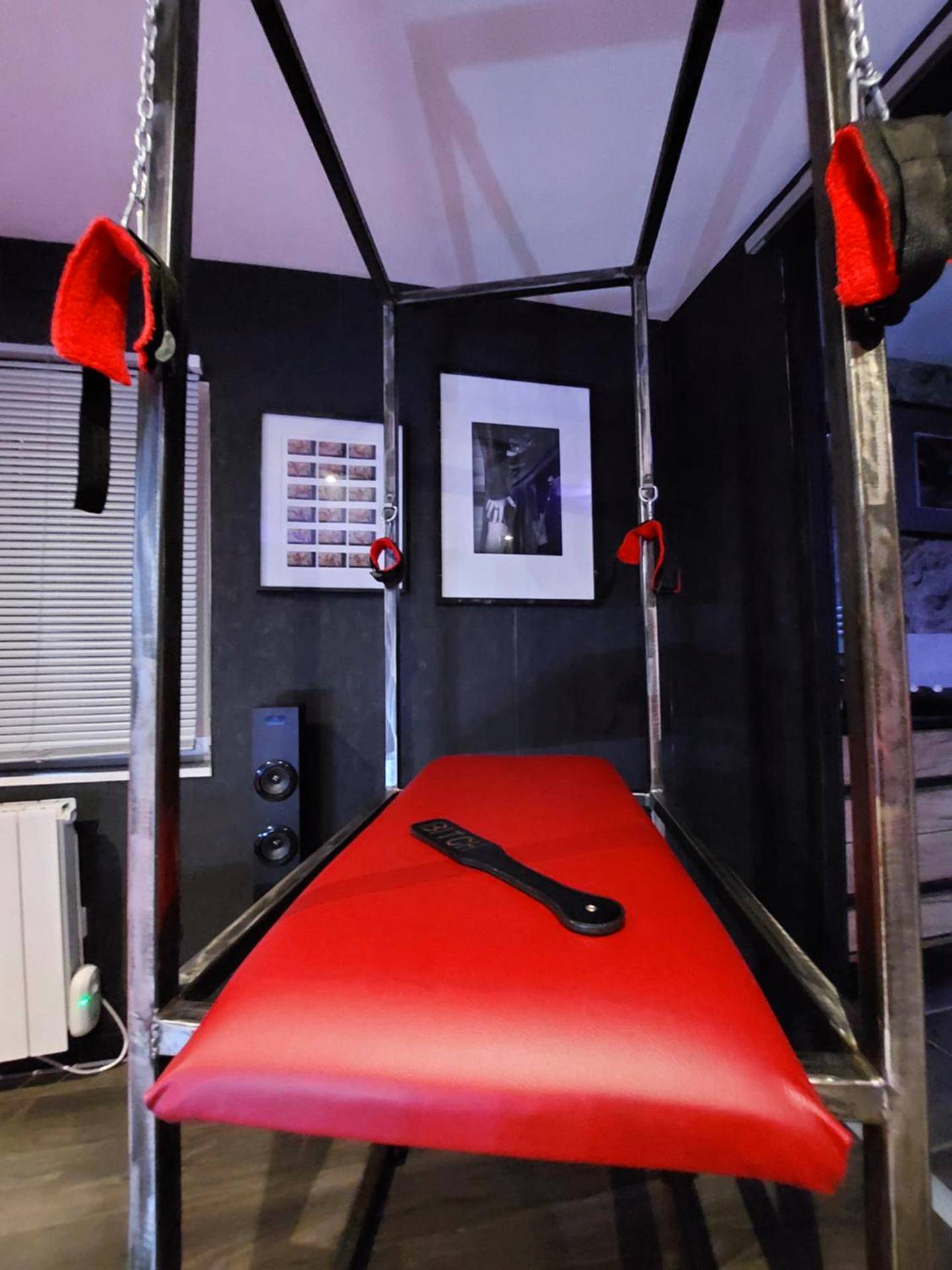 Table de massage rouge avec menottes - PLAISIR EXTREME