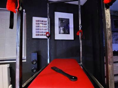Table de massage rouge avec menottes - PLAISIR EXTREME