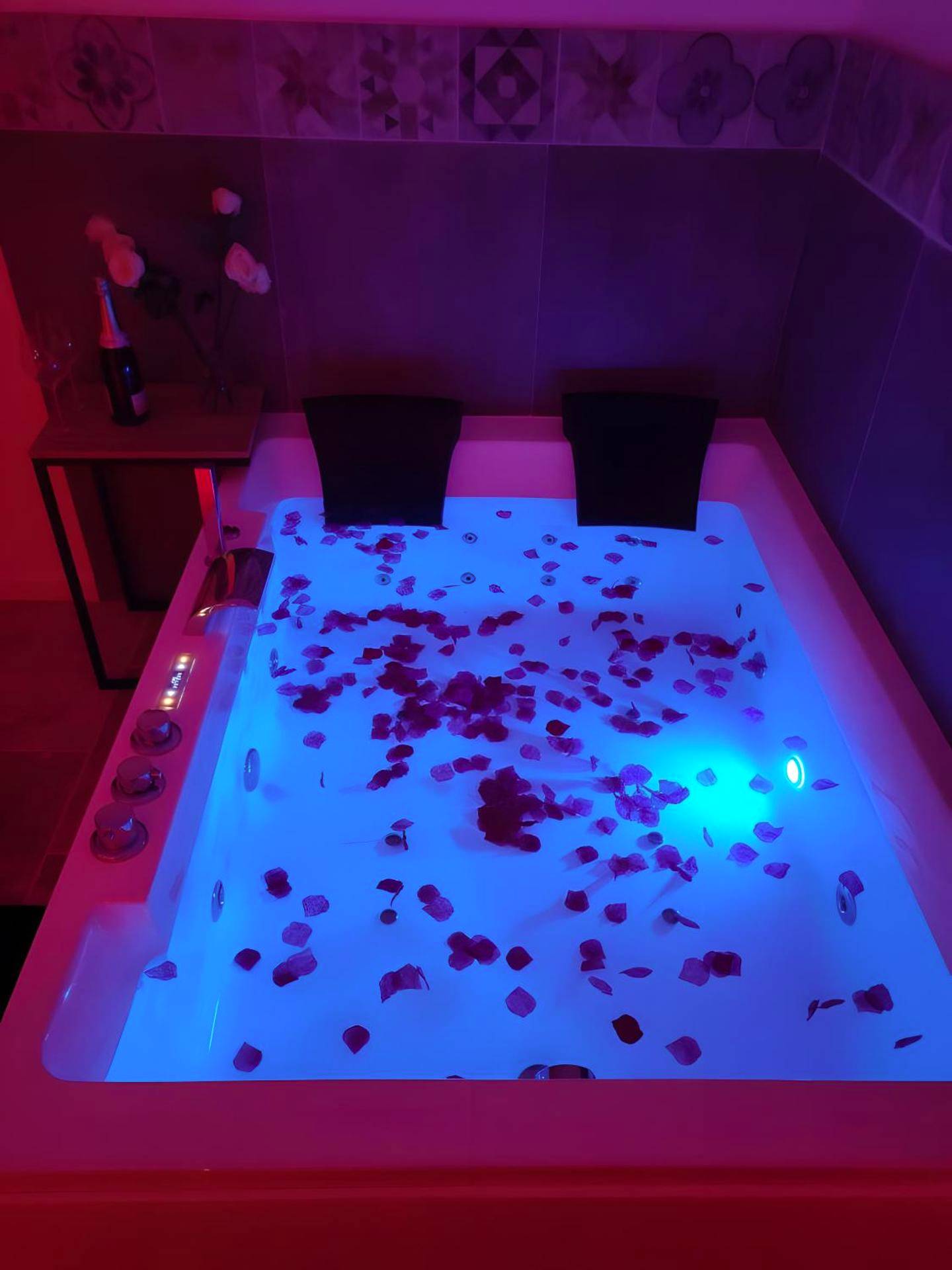 Baignoire balnéo éclairée en bleu avec pétales - Le Plaisir Des Sens
