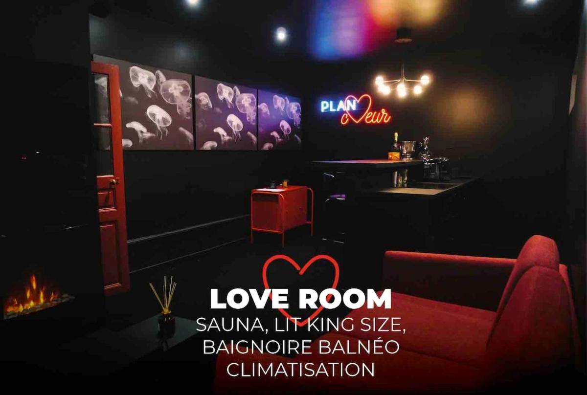 Salon avec néon et fauteuil rouge - Love Room Riom - PLAN COEUR Romantic Experience & Spa