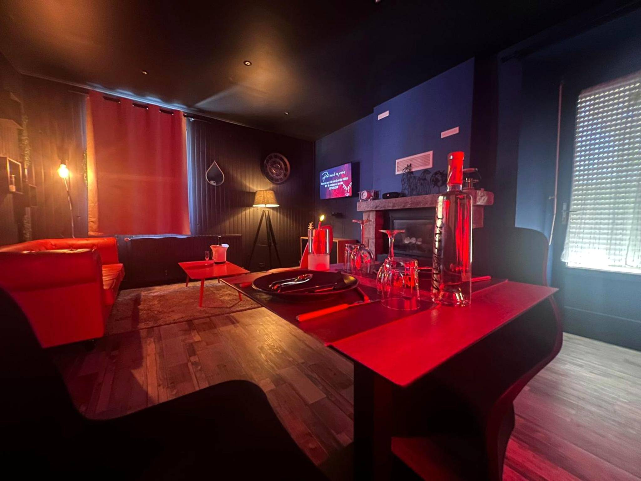 Espace dînatoire romantique éclairé en rouge - LoveRoom avec SPA privatif Plélo