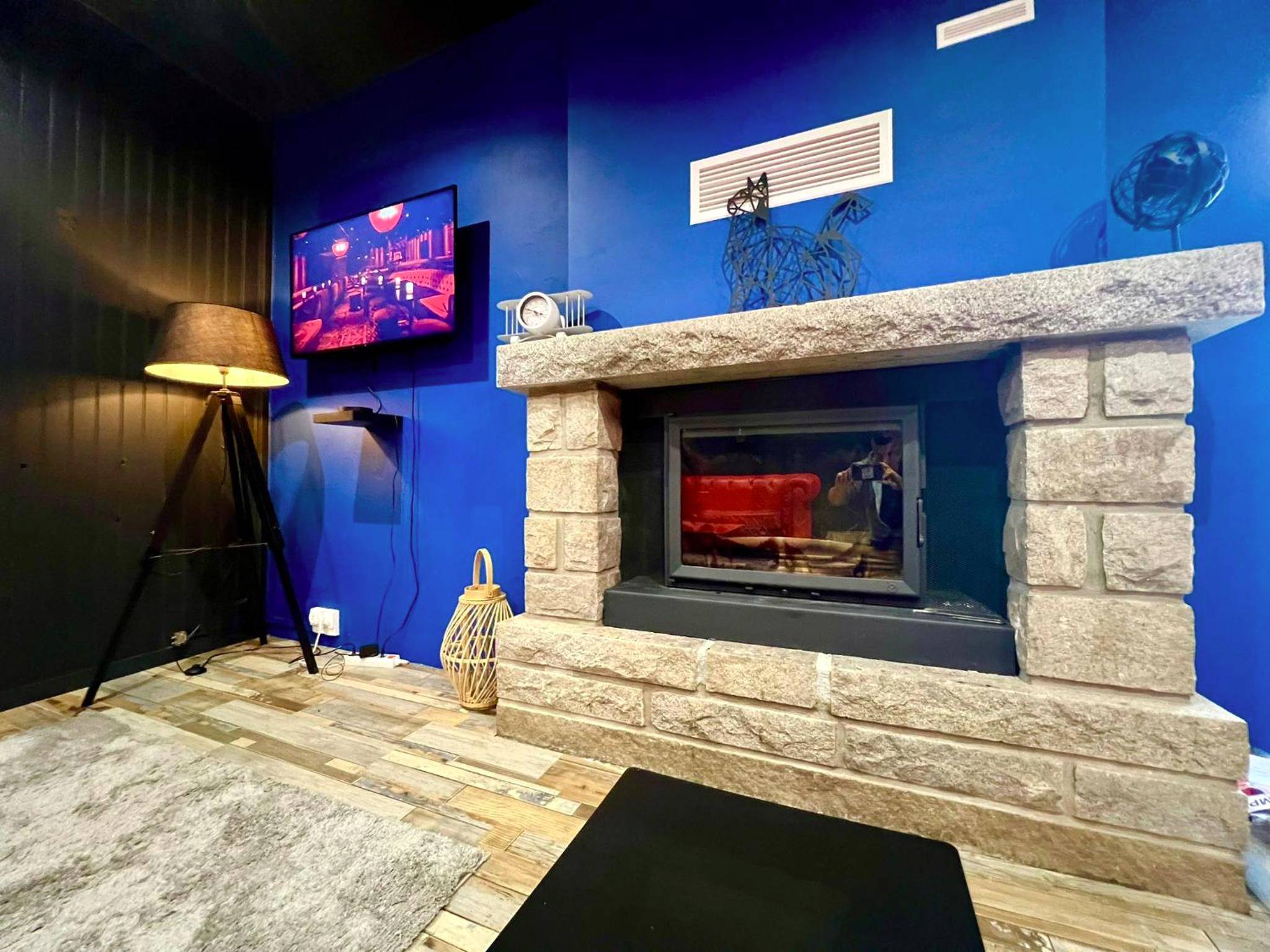 Cheminée en pierre et mur bleu avec TV - LoveRoom avec SPA privatif Plélo