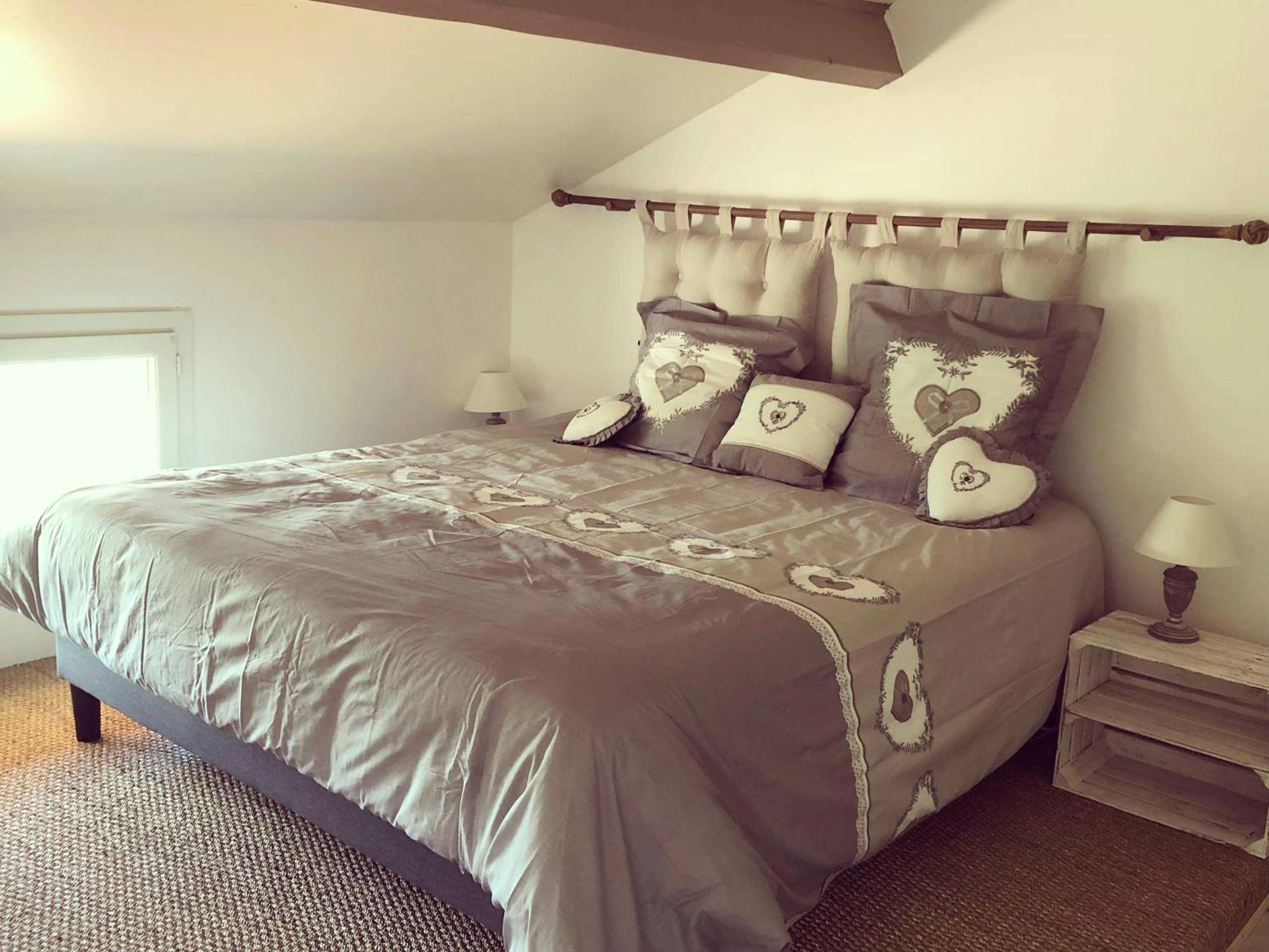 Chambre mansardée avec lit double et coussins - La pomme d’amour