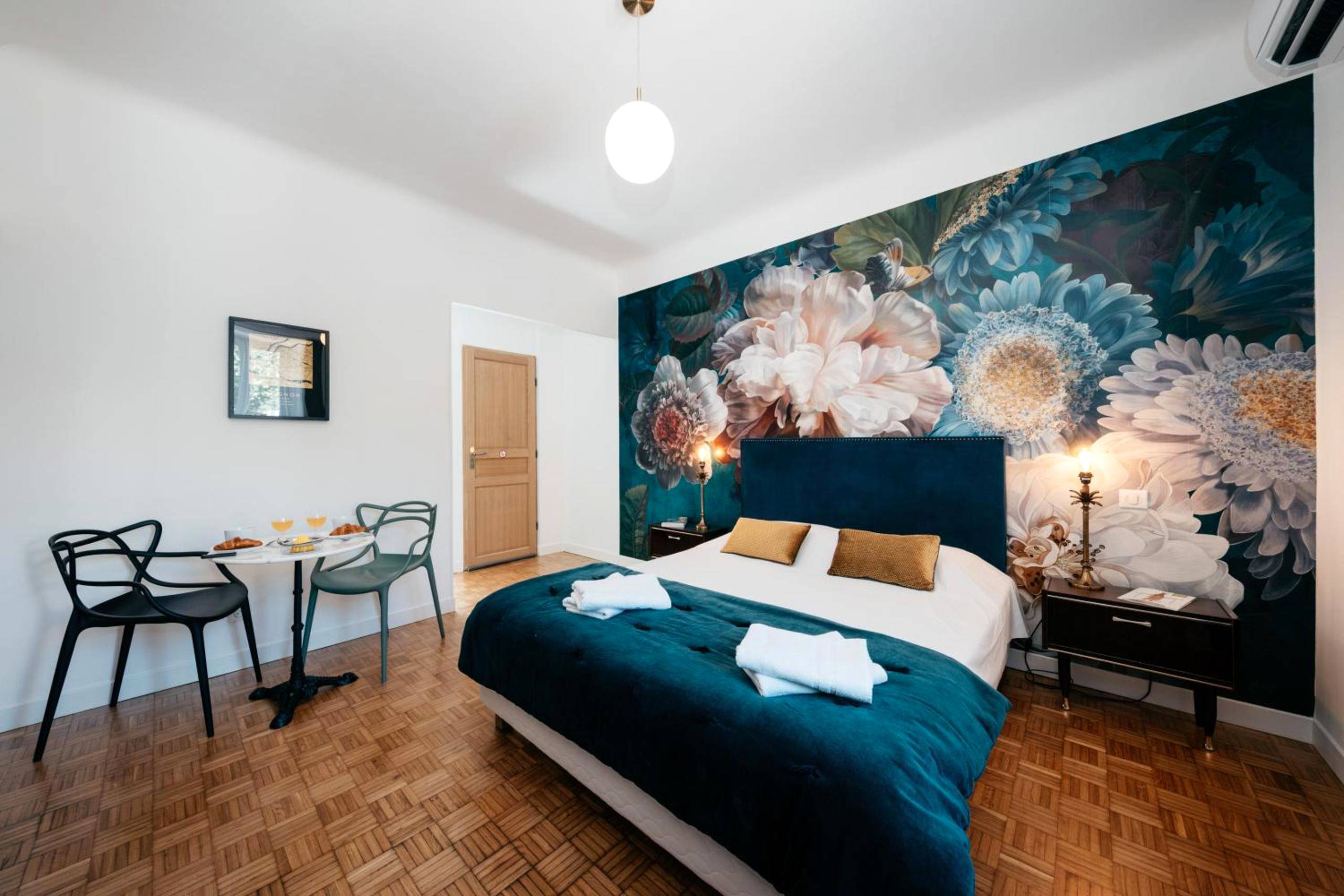 Chambre avec coin repas et mur fleuri - Les Précieuses Suites & Spa II