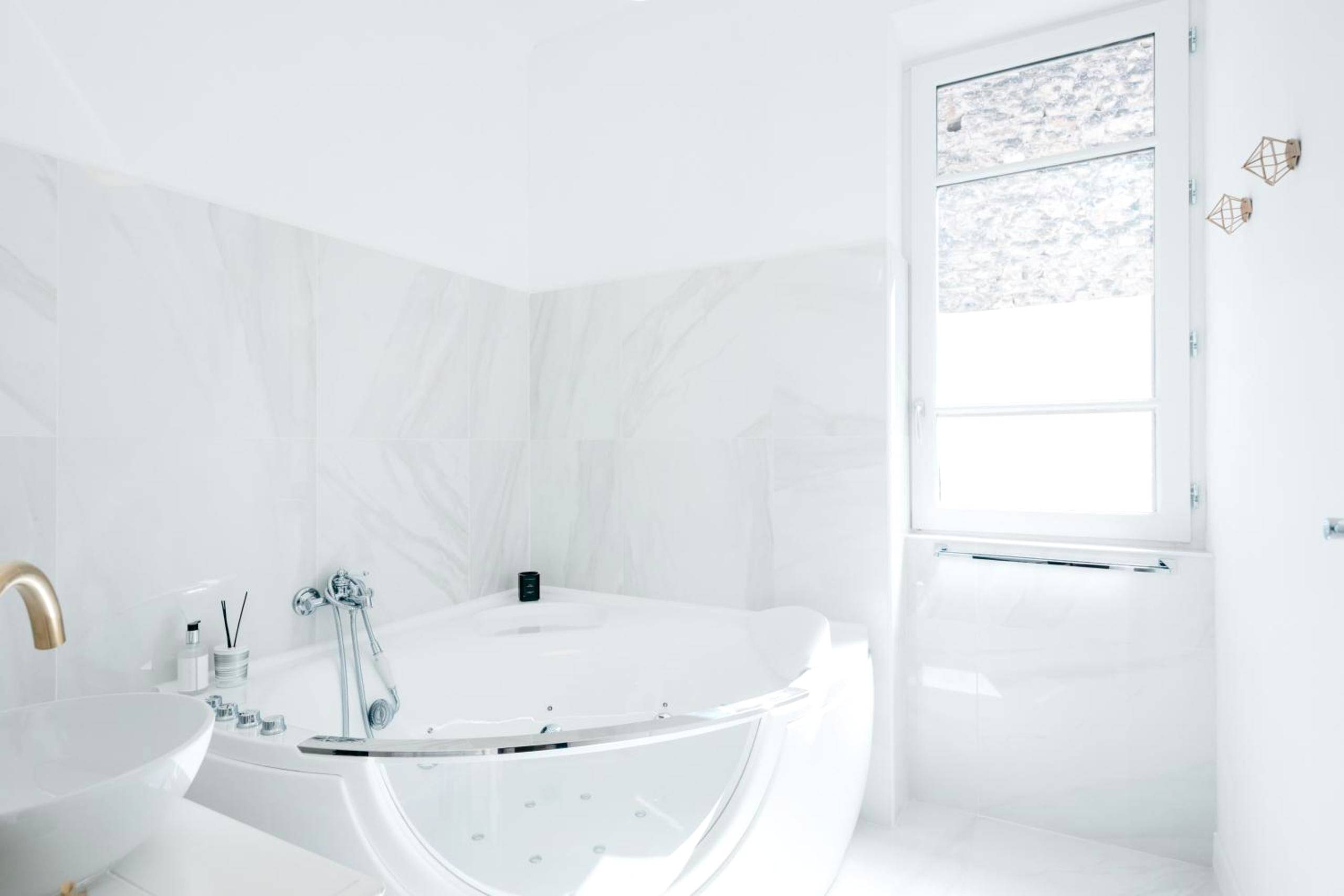 Baignoire balnéo dans une salle de bain blanche - Les Précieuses Suites & Spa II