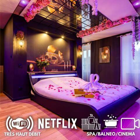 Lit king size avec pétales et cygnes en serviette - Love Room Roannes - Saint - Mary - La prestigieuse Sauna Balnéo Ciné