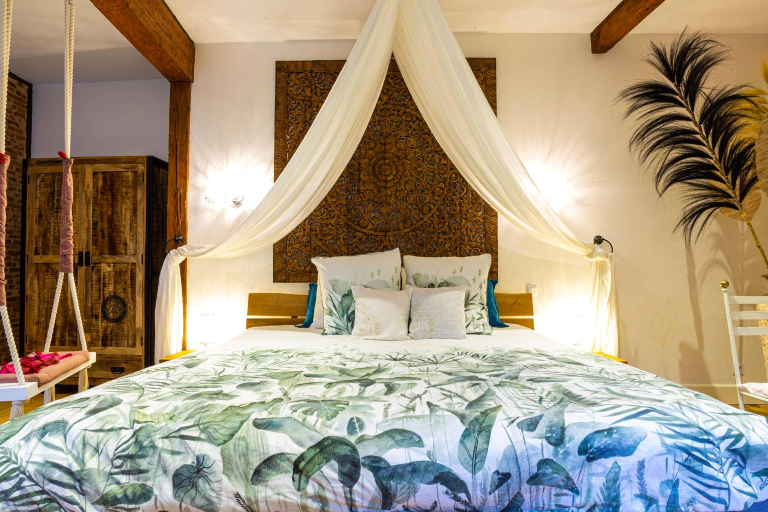 Lit double avec baldaquin et tête de lit sculptée - Love Room Verfeil - LE PRIEURE - Suites romantiques spa privatif,...