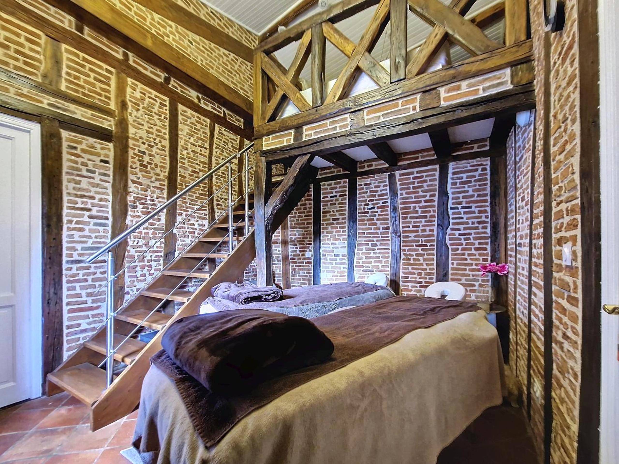 Espace massage avec deux tables et murs en briques - LE PRIEURE - Suites romantiques spa privatif, piscine, jardin,...