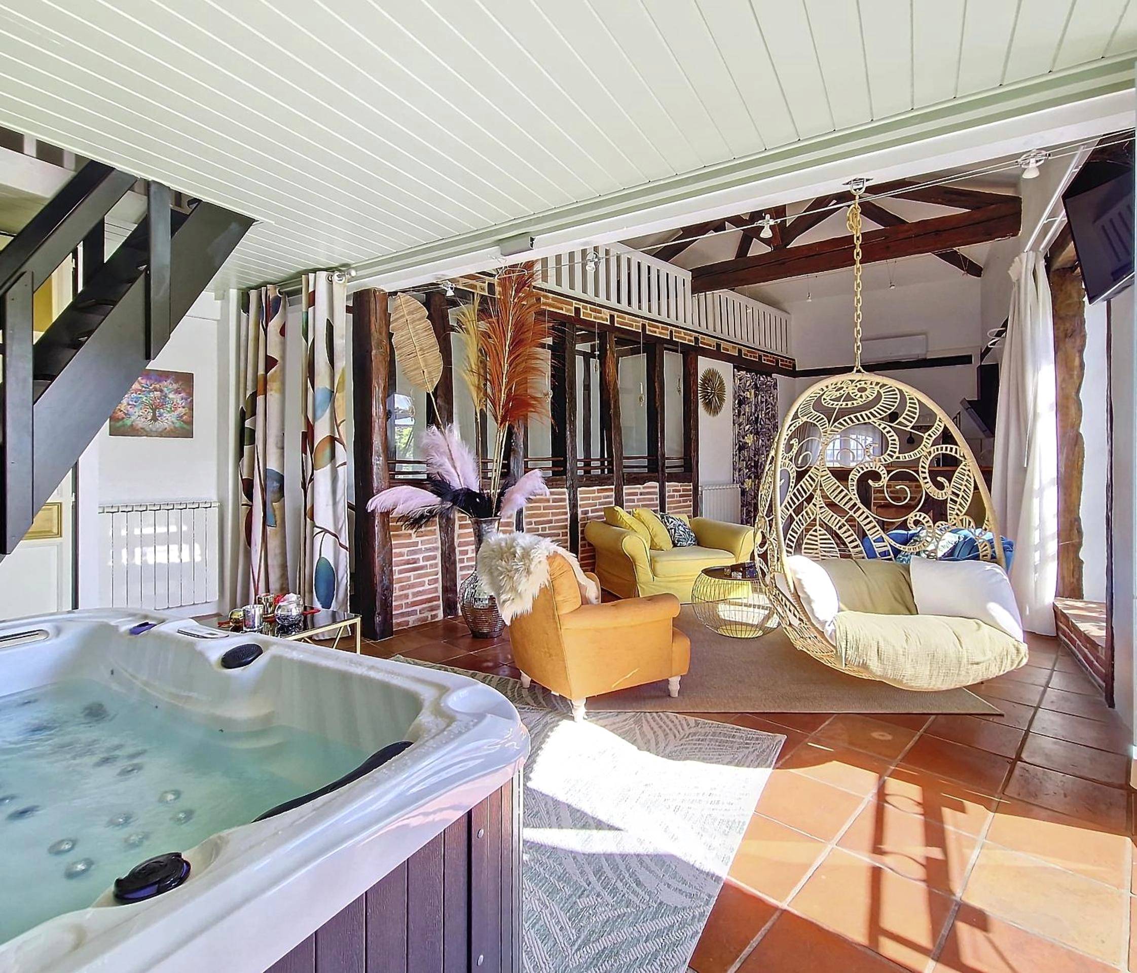 Salon avec jacuzzi privatif et fauteuil suspendu - LE PRIEURE - Suites romantiques spa privatif, piscine, jardin,...