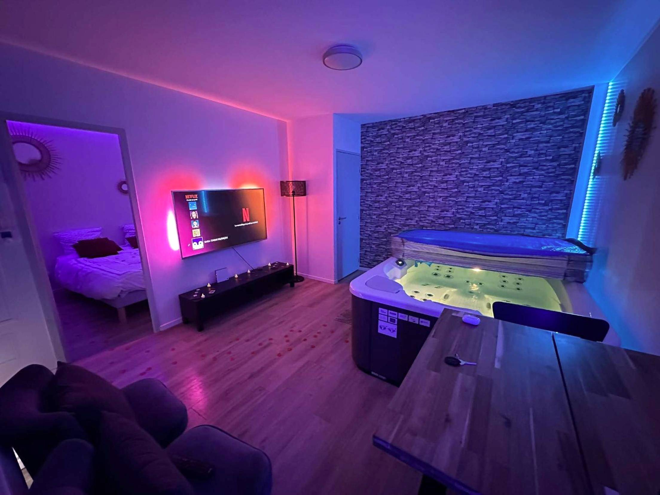 Jacuzzi privatif et salon avec ambiance néon - Love Room Toulouse - Priv8Spa New Love Room Jacuzzi Privée