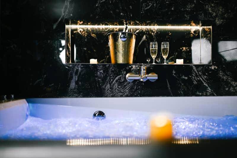 Détail du jacuzzi avec champagne et bougies - Promesse d'une nuit avec Balnéo privative
