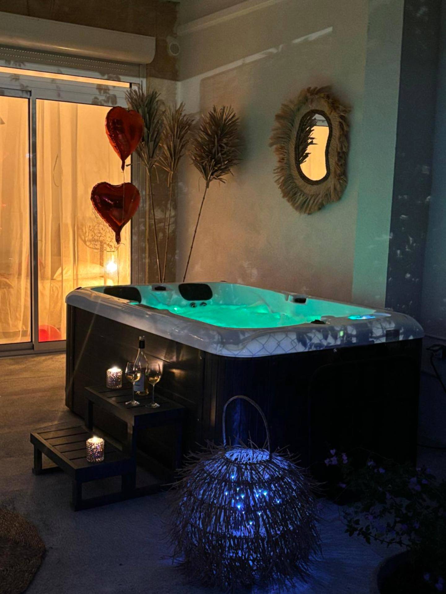 Jacuzzi extérieur avec éclairage vert et ballons - Love Room Quissac - Appartement cosy Quissac avec Jacuzzi