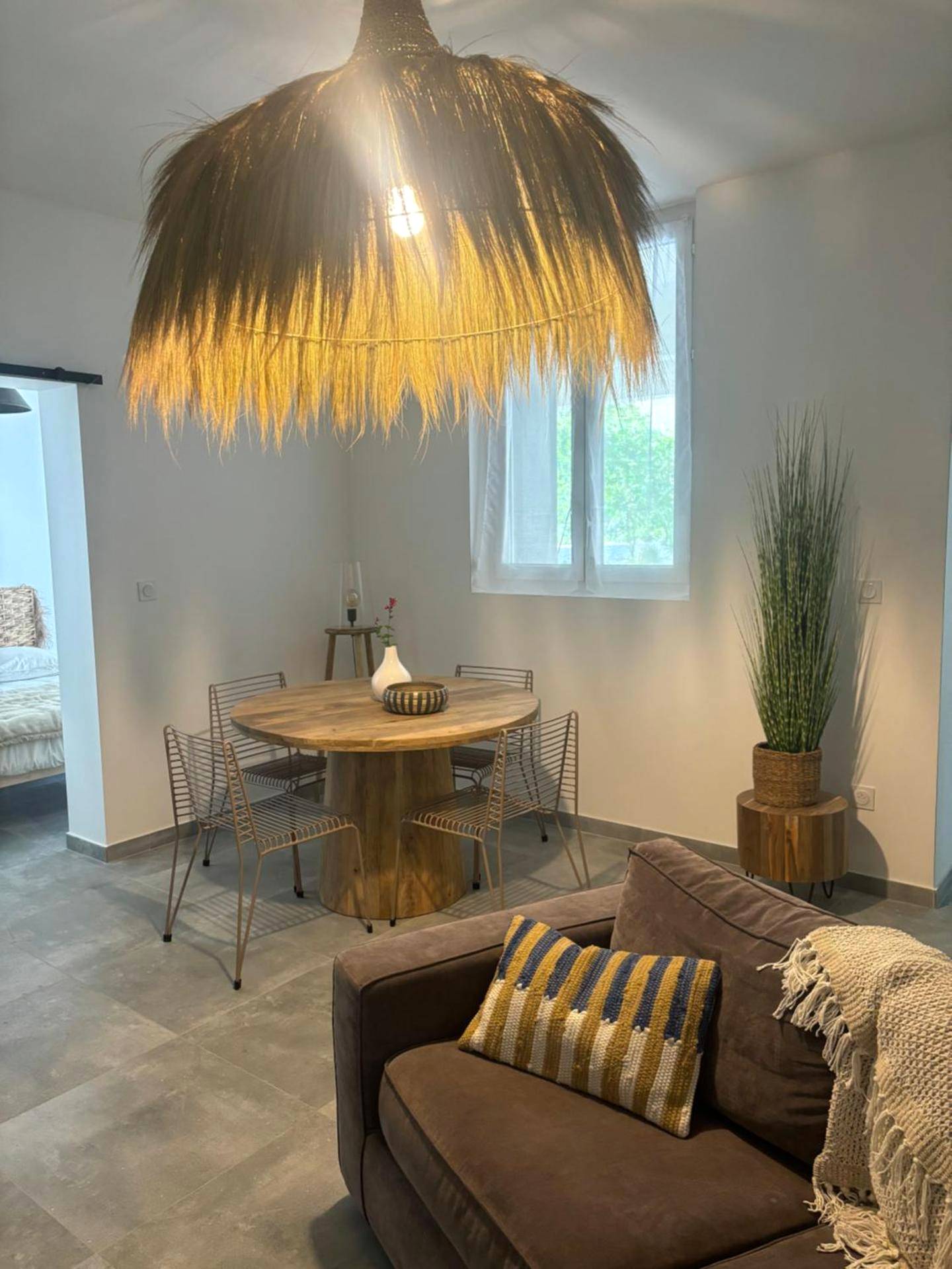 Espace salon et table à manger ronde en bois - Appartement cosy Quissac avec Jacuzzi